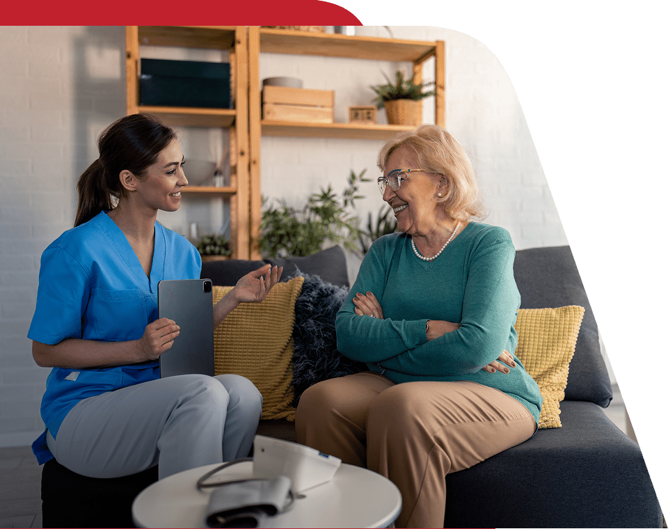Healthcare worker talking with an elderly woman.